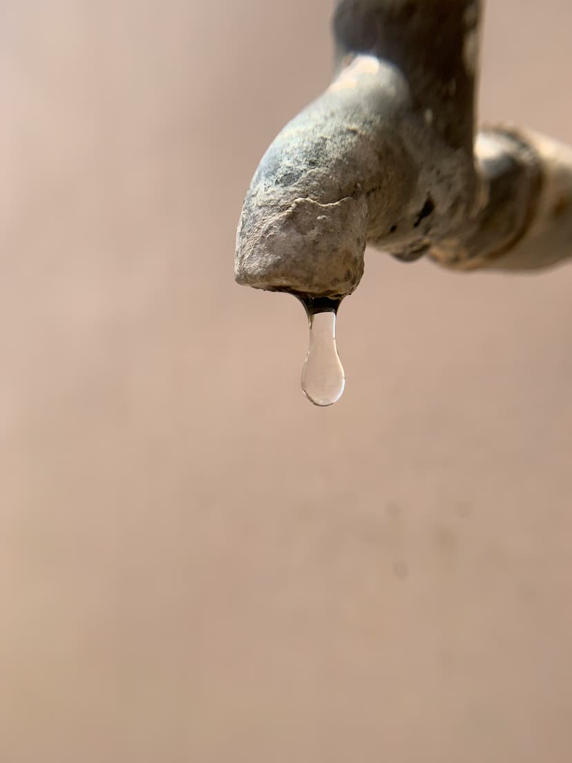 Dripping faucet showing hard water mineral buildup